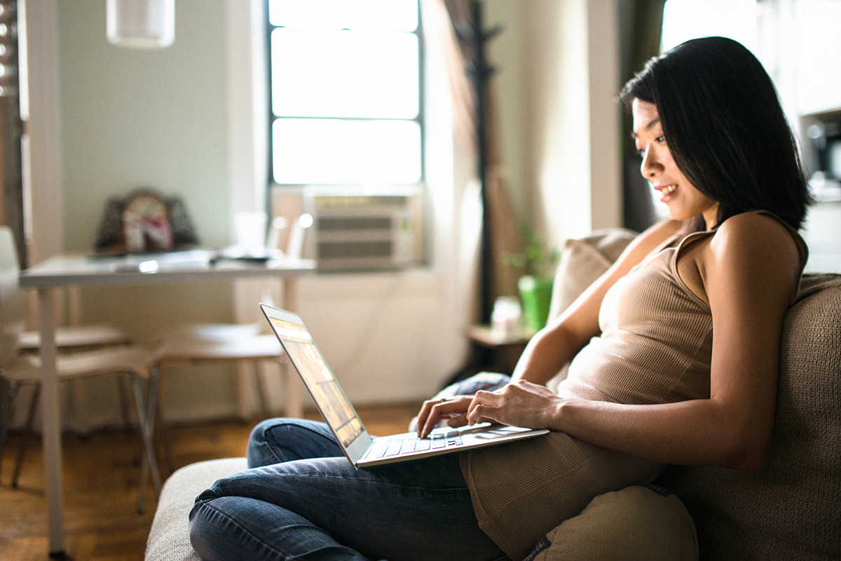 Woman researching renting her home out on laptop